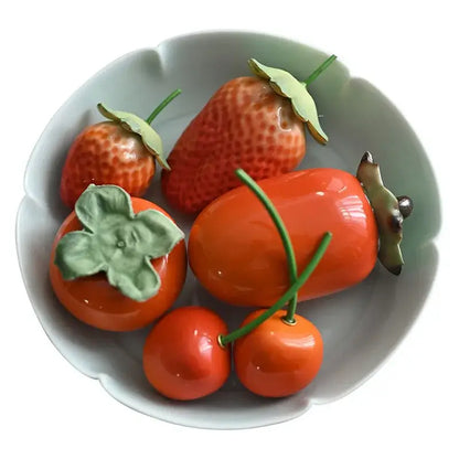 Glossy red ceramic fruit sculpture tea caddy featuring vibrant strawberries persimmons and cherries with green leaves