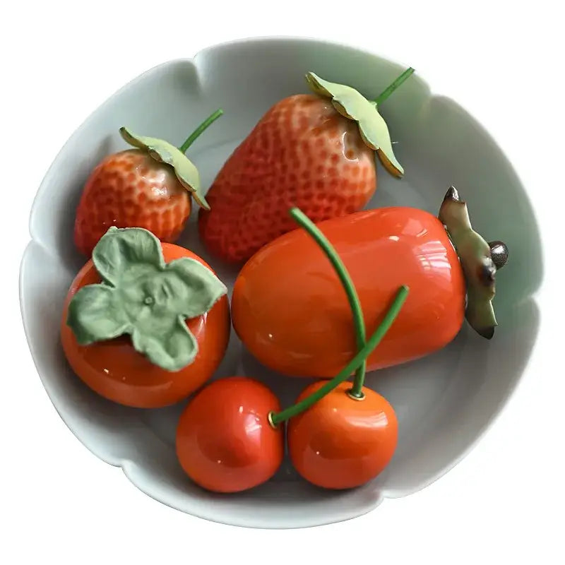 Glossy red ceramic fruit sculpture tea caddy featuring vibrant strawberries persimmons and cherries with green leaves