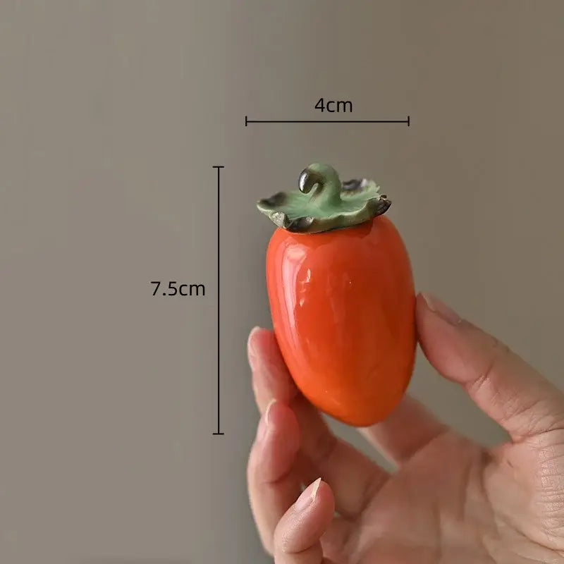 Glossy orange ceramic persimmon fruit sculpture tea caddy with green leafy top for kitchen decor measuring 7.5cm tall