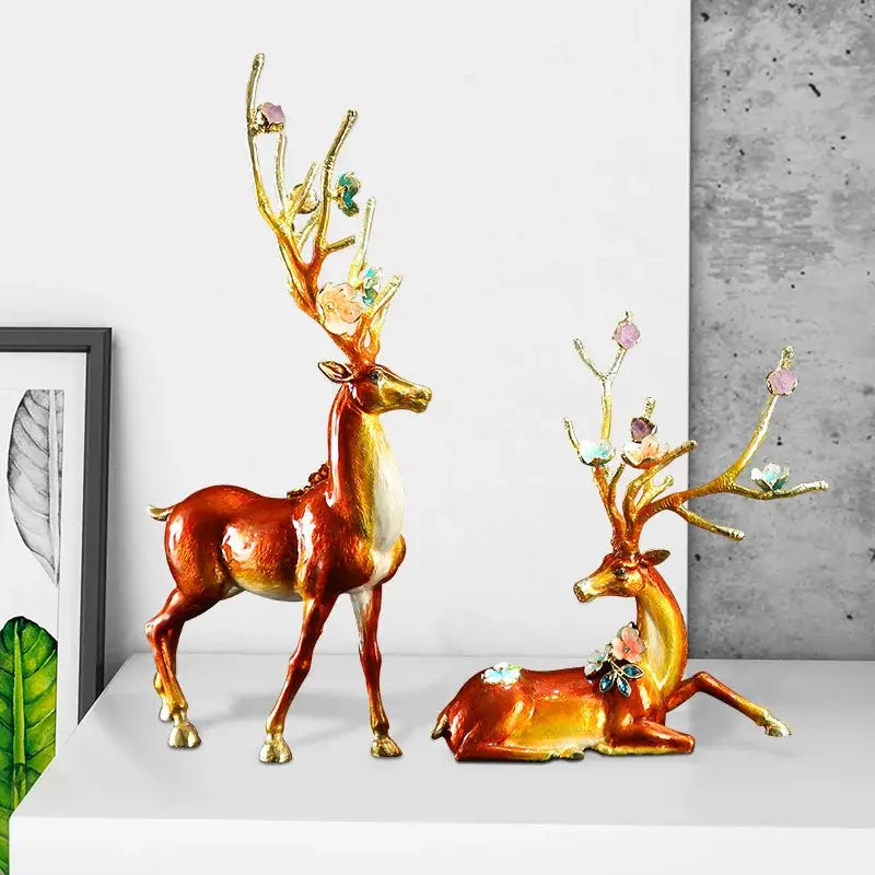 Two glossy resin deer figurines with amber body gold accents and gemstone flowers in a deer peace porch decoration set