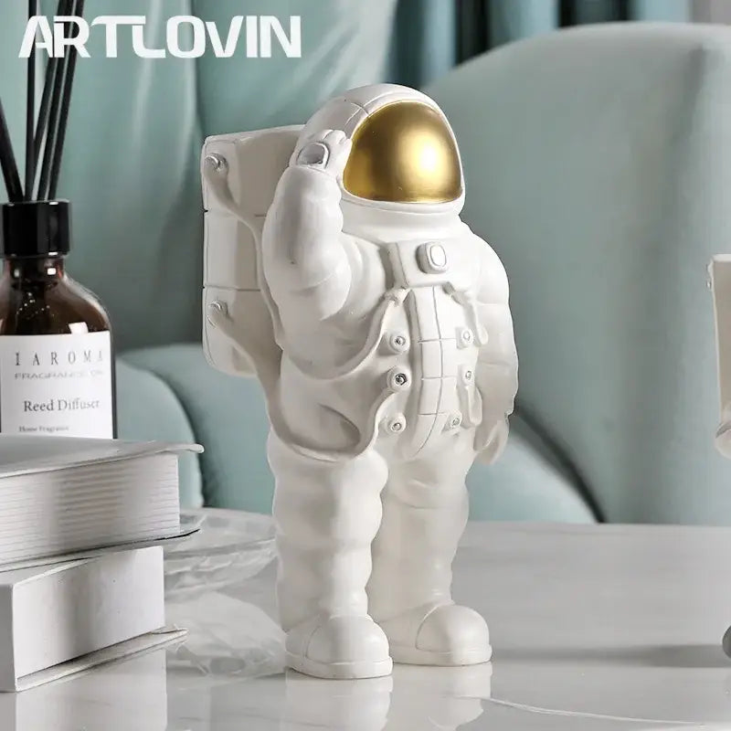 Glossy white and gold resin astronaut phone holder with a gold helmet for bedroom decor and phone holding