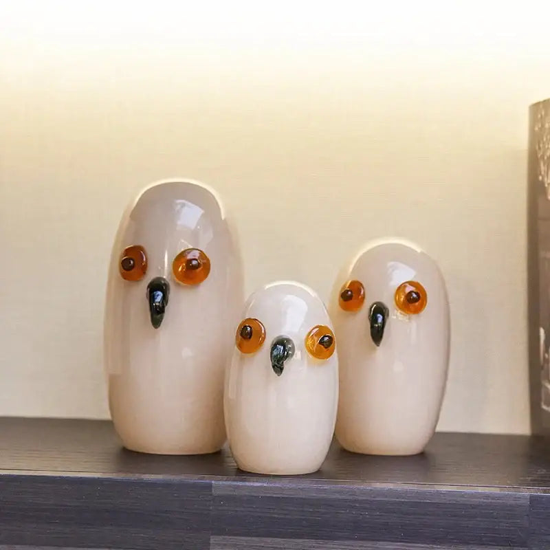Three glossy white cartoon owl glass sculptures with amber eyes and black beaks for home decor by decorbites cartoon owl