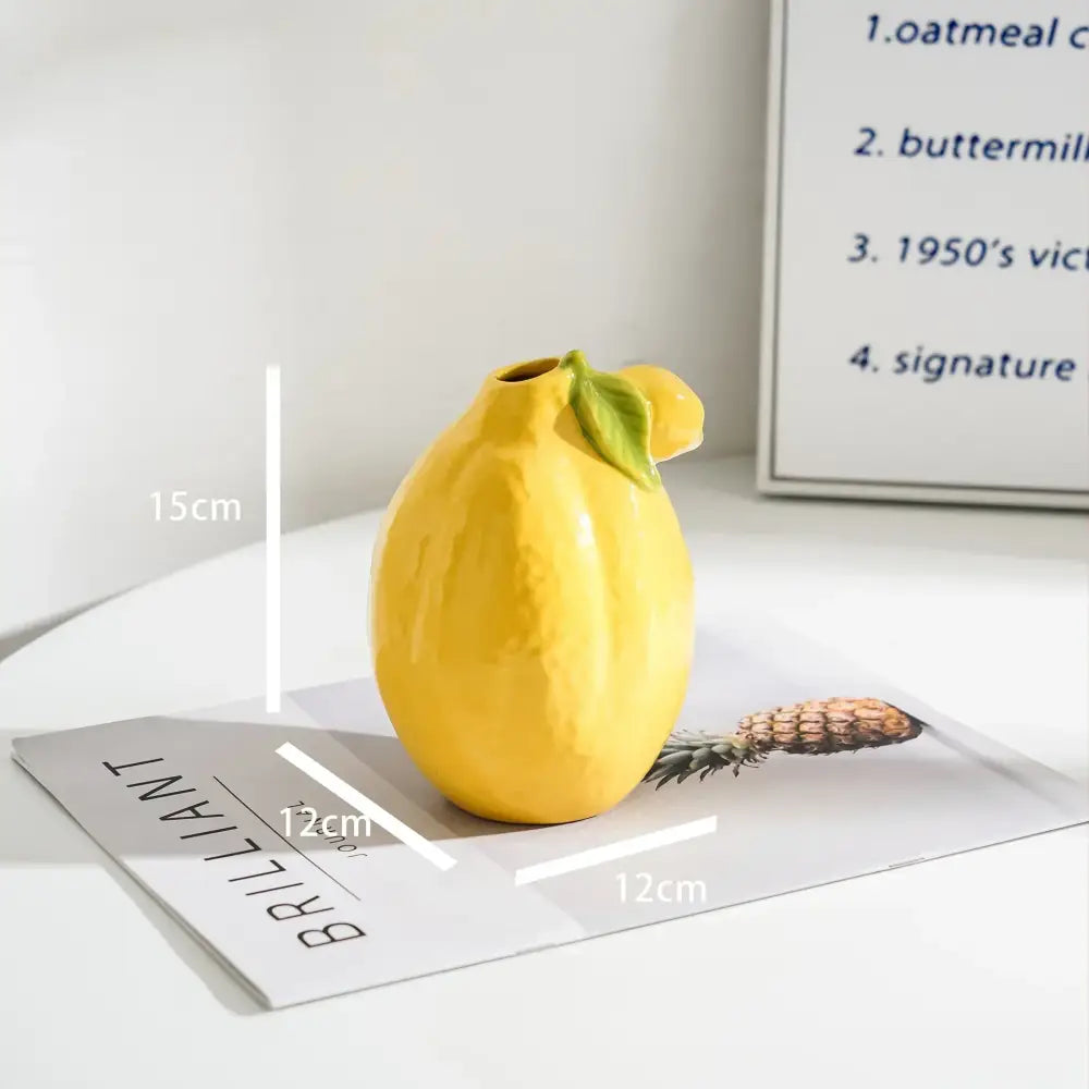 Glossy yellow ceramic lemon flower vase with green leaf accent for kitchen citrus decor by decorbites lemon