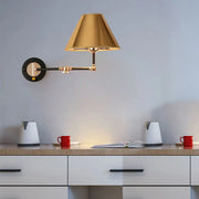 Gold and black metal cone wall light swing arm sconce with an adjustable conical shade and circular mounting plate
