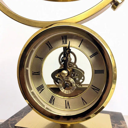 Golden skeleton clock with roman numerals and exposed gears on marble base for clock globe decoration decorbites clock globe