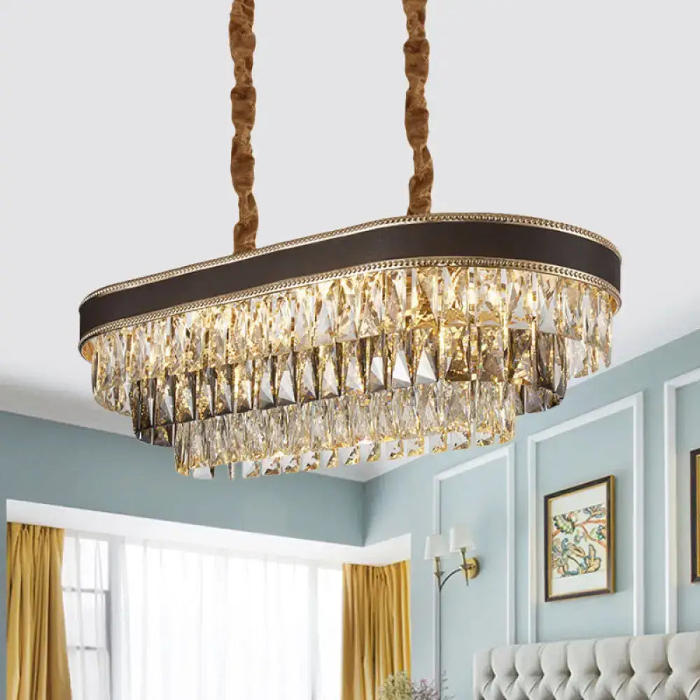 Gold-toned ellipse island pendant with cascading crystal prisms and dark brown leather-like trim for island lighting