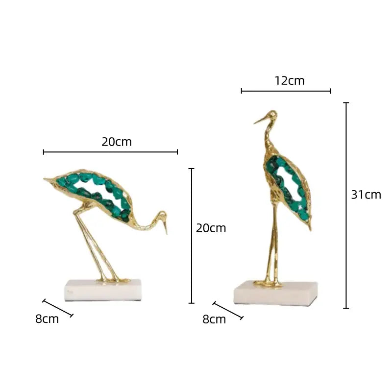 Gold and emerald crystal crane sculpture with emerald gemstone accents on white marble base for living room decor