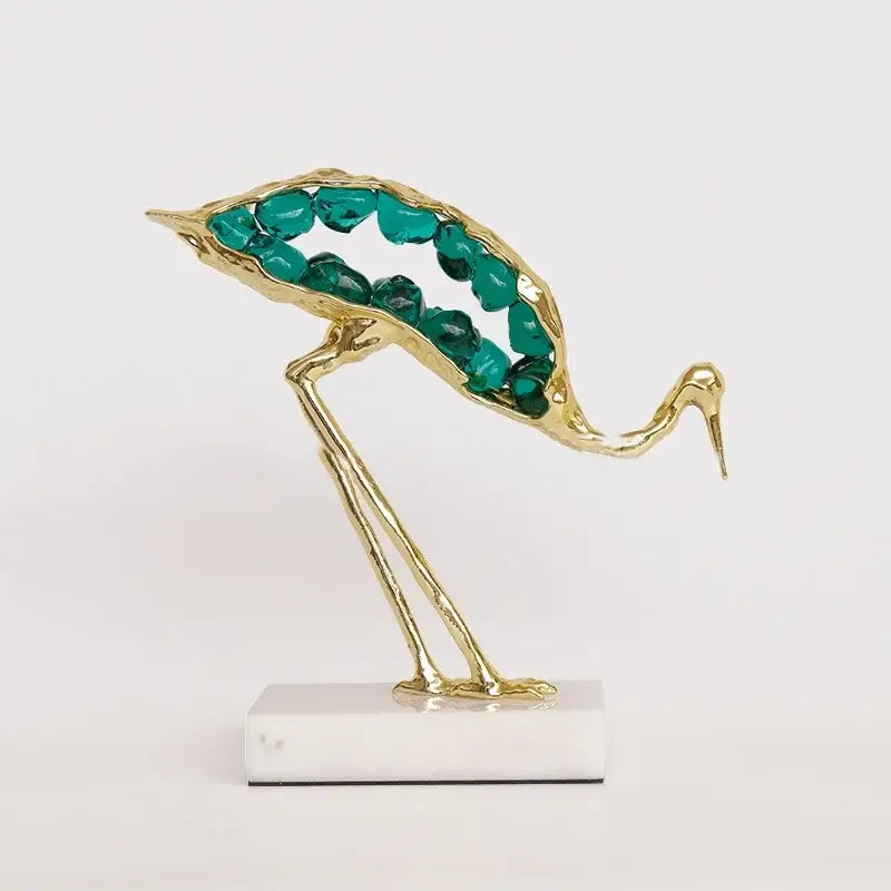 Gold and emerald crystal crane sculpture with green gemstones on white marble base for living room decor