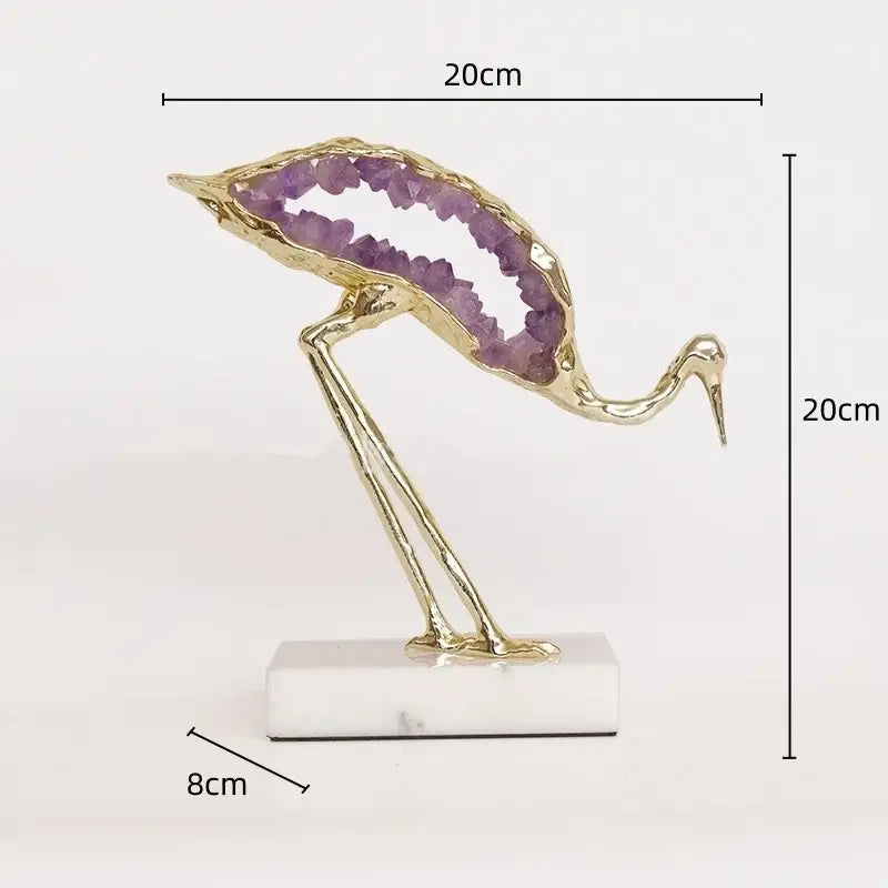 Gold-toned crystal crane sculpture with purple amethyst interior on white marble base for living room decor