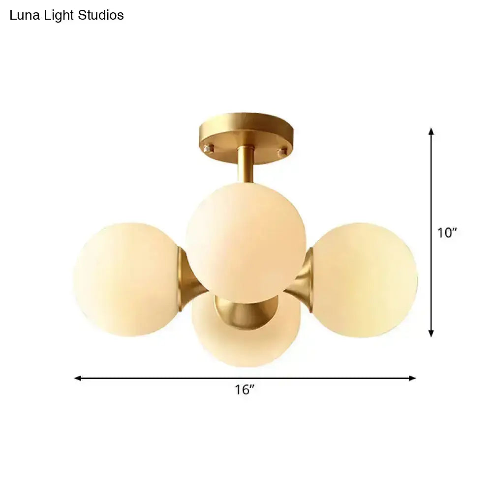 Gold-toned semi-flush mount ceiling fixture with four frosted opaline glass globes for 220v-240v 110v-120v use