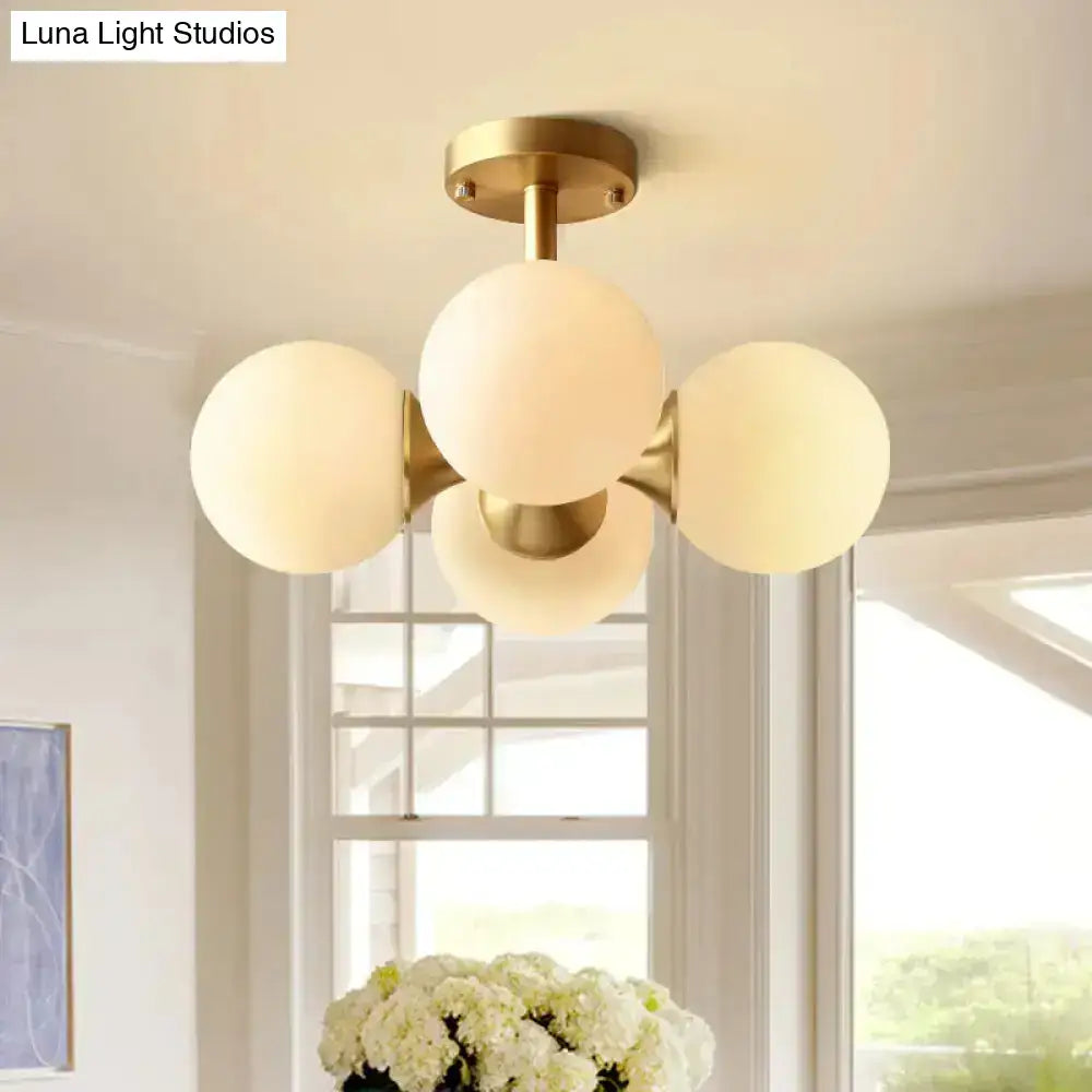 Gold-toned semi-flush mount ceiling light with four opaline glass globe shades compatible with 220v-240v 110v-120v