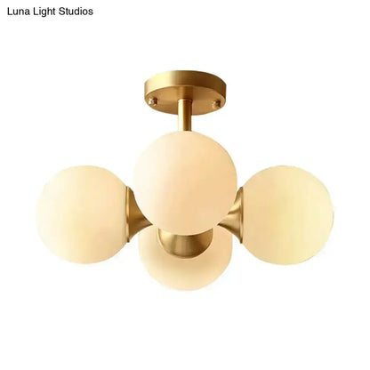 Gold-toned semi-flush mount ceiling fixture with four frosted opaline glass globes for 220v-240v 110v-120v use