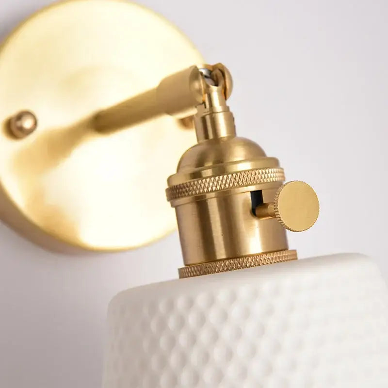 Gold-toned brass wall sconce with textured white ceramic shade decorbites ceramic led wall for bedroom use
