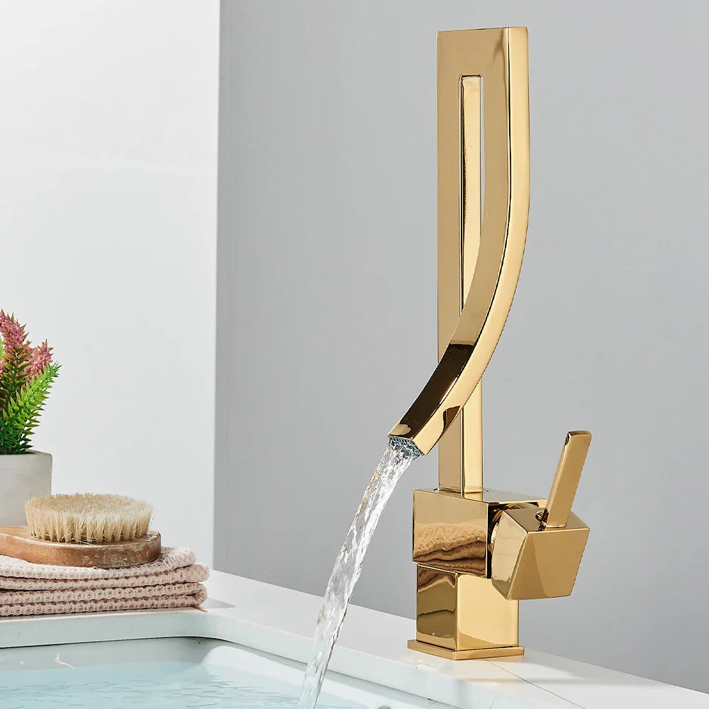 Gold-colored single hole bathroom basin faucet deck mounted with sleek angular design and flowing water stream