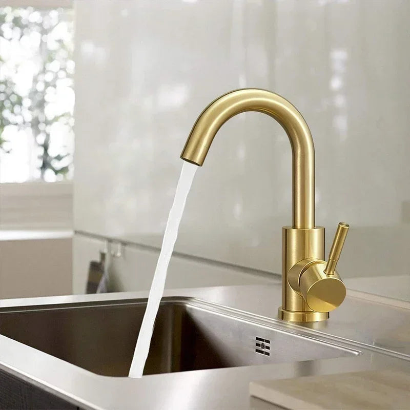 Gold bathroom faucet with stainless steel construction featuring a modern curved spout and cylindrical handle