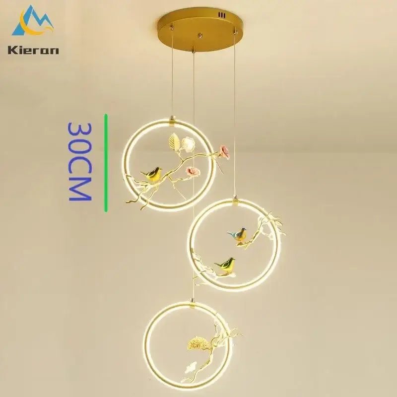 Gold-toned kieron decorbites bird led chandelier with three circular led rings and bird branch sculptures for dining room decor