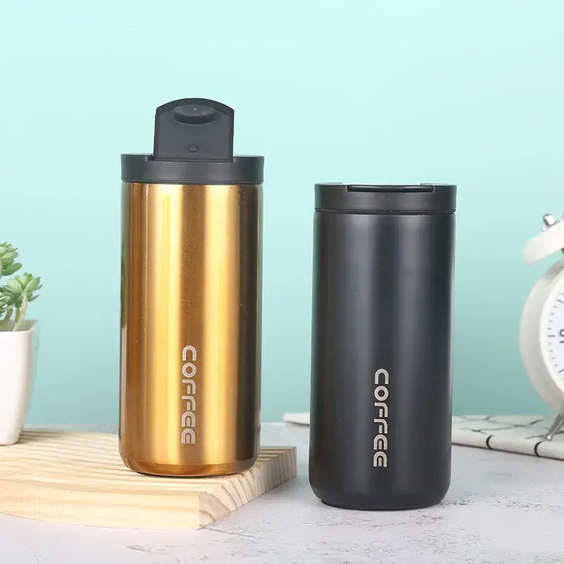 Two metallic decorbites insulated espresso cups in brushed gold and matte black with coffee inscription for travel use