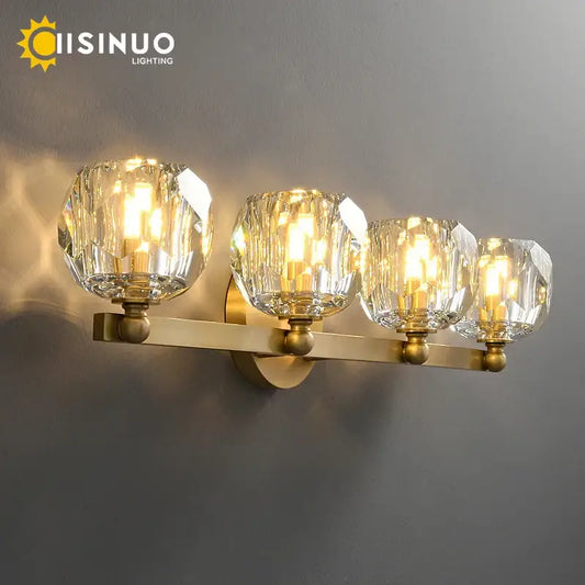 Brass-finished wall-mounted vanity light with four faceted crystal glass shades ideal for bathroom vanity light fixtures