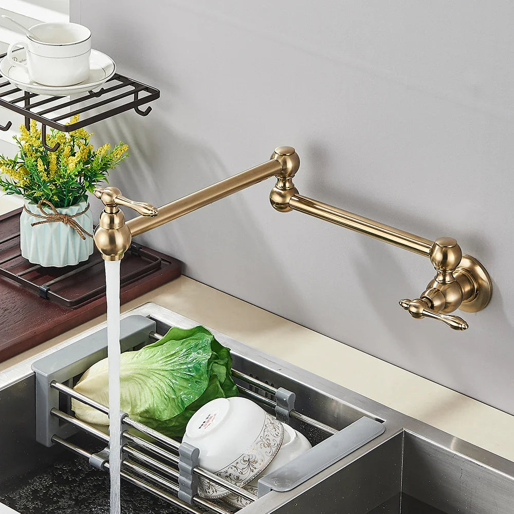 Gold brass pot filler wall mounted faucet in brass color with extendable spout and ornate handles for kitchen use