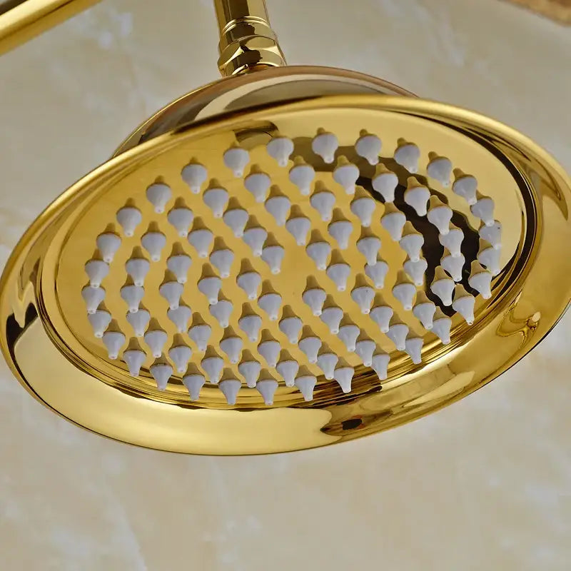 Gold-colored oval brass rainfall shower faucet set with polished metallic finish and white ceramic nozzles for bathroom use