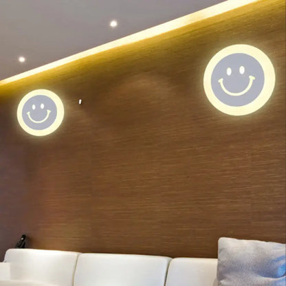 Two gold and brown crescent led wall lights with smiling faces emitting warm glow for children’s bedroom wall light