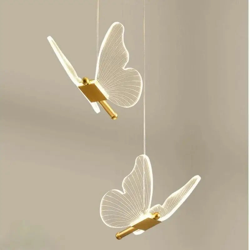 Gold butterfly acrylic chandelier pendant lamp featuring elegant translucent wings and gold-toned metallic bodies for bedroom lighting