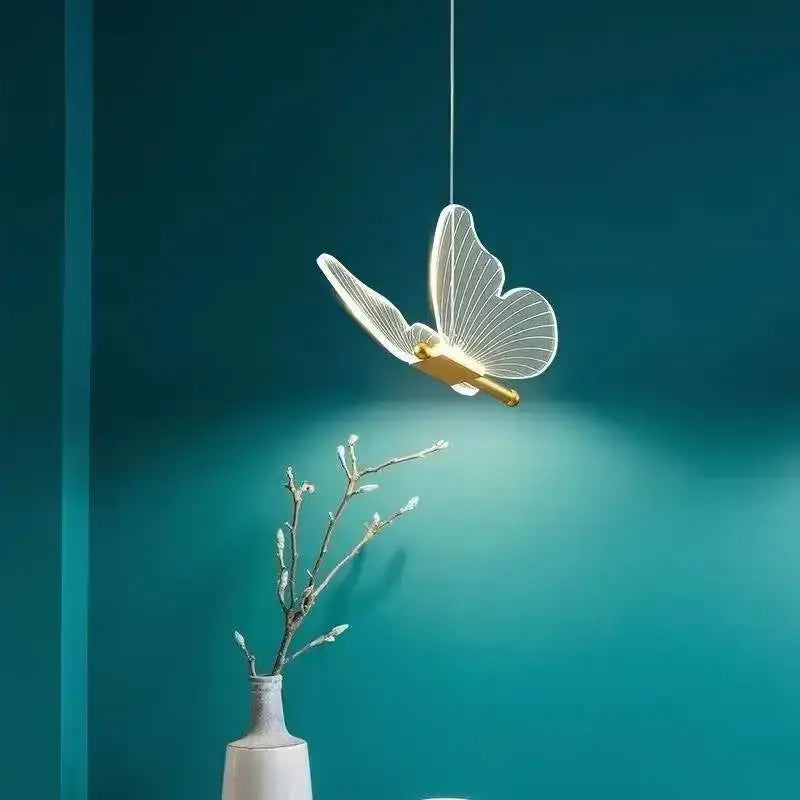 Gold butterfly acrylic chandelier pendant lamp with translucent illuminated wings and gold-toned accents for bedroom lighting