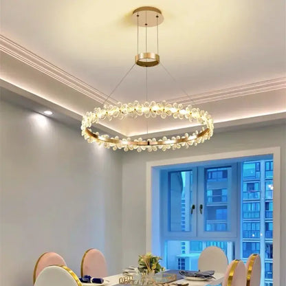 A modern gold-toned decorbites crystal led chandelier with clear flower-shaped crystals for living room decor