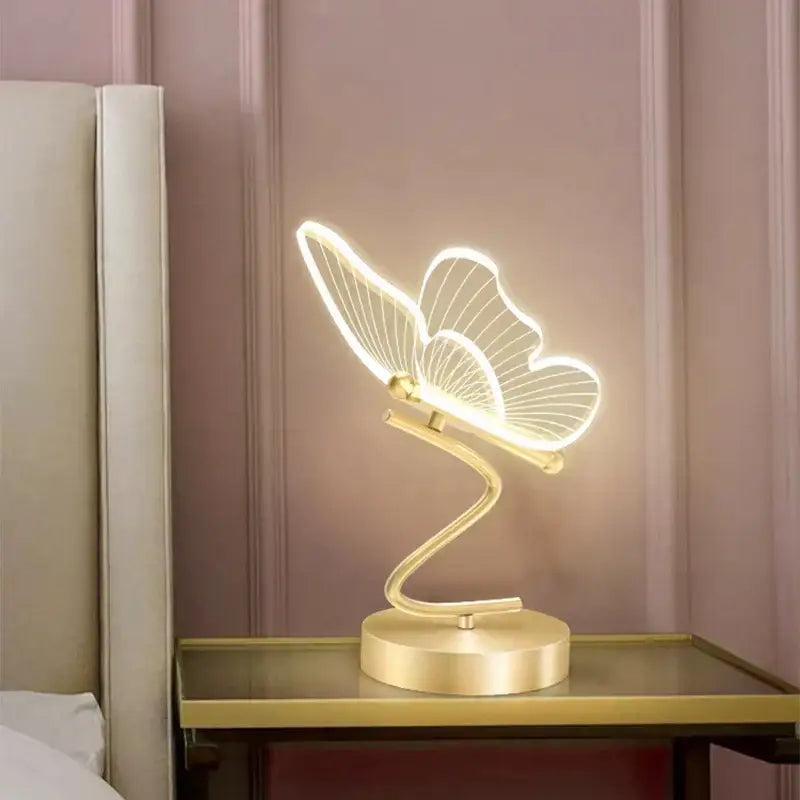 Gold-toned butterfly led table lamp with illuminated wings and sleek curved base for bedroom decorbites butterfly led light