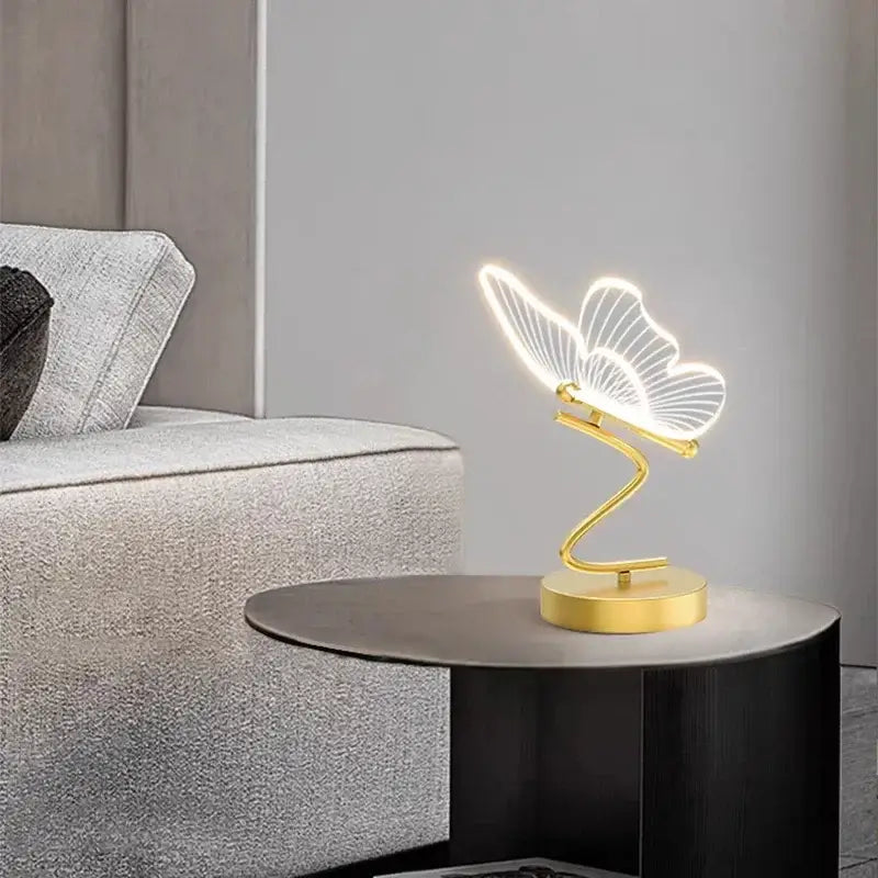 Gold-toned butterfly led table lamp with illuminated translucent wings and sleek curved base for bedroom decorbites butterfly led decor