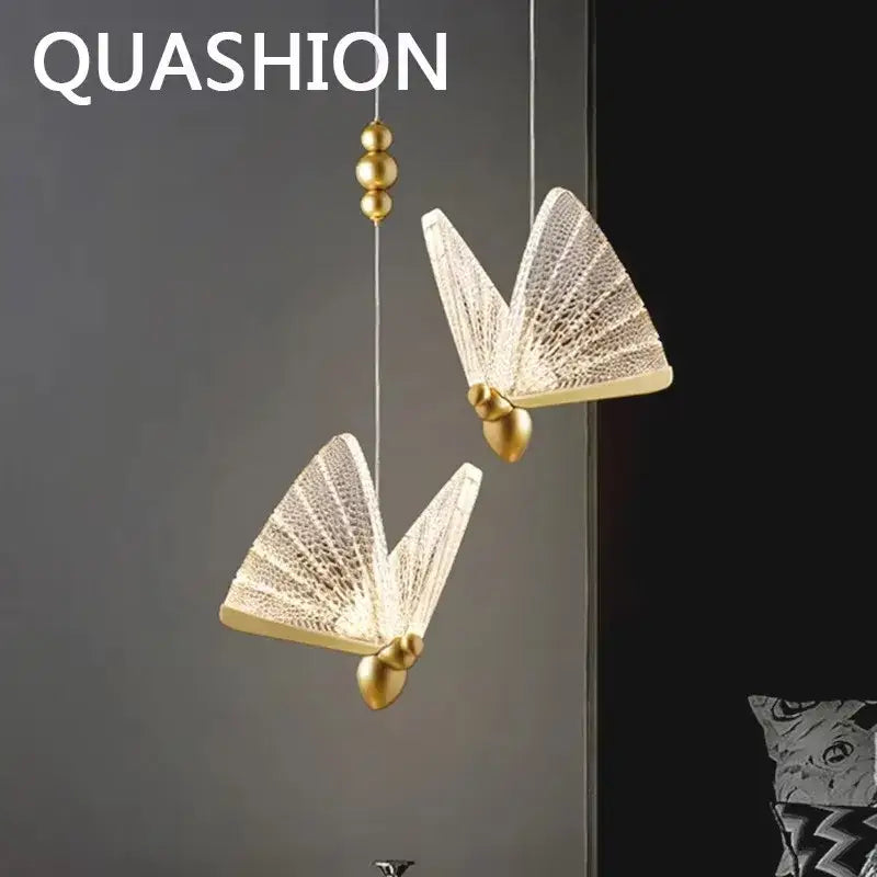 Gold butterfly pendant light with acrylic elements and gold accents features translucent patterned wings and works beautifully in bedroom
