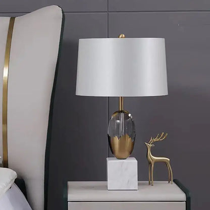 Modern fabric table lamp with white shade gold-toned crystal fabric base and marble pedestal for bedroom decor