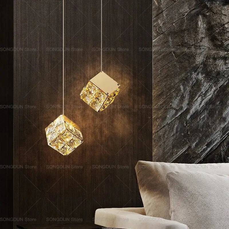 Two gold-toned crystal bedside chandelier wall lights with cube pendants against dark wood panel decorbites crystal bedside