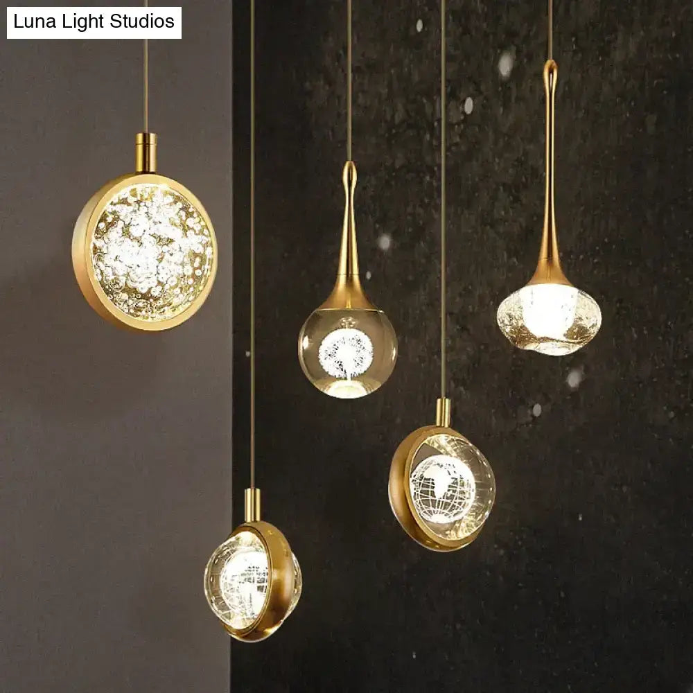 Gold-toned DecorBites™ Clara LED crystal glass pendant lights with clear globes and warm glowing illumination for indoor use