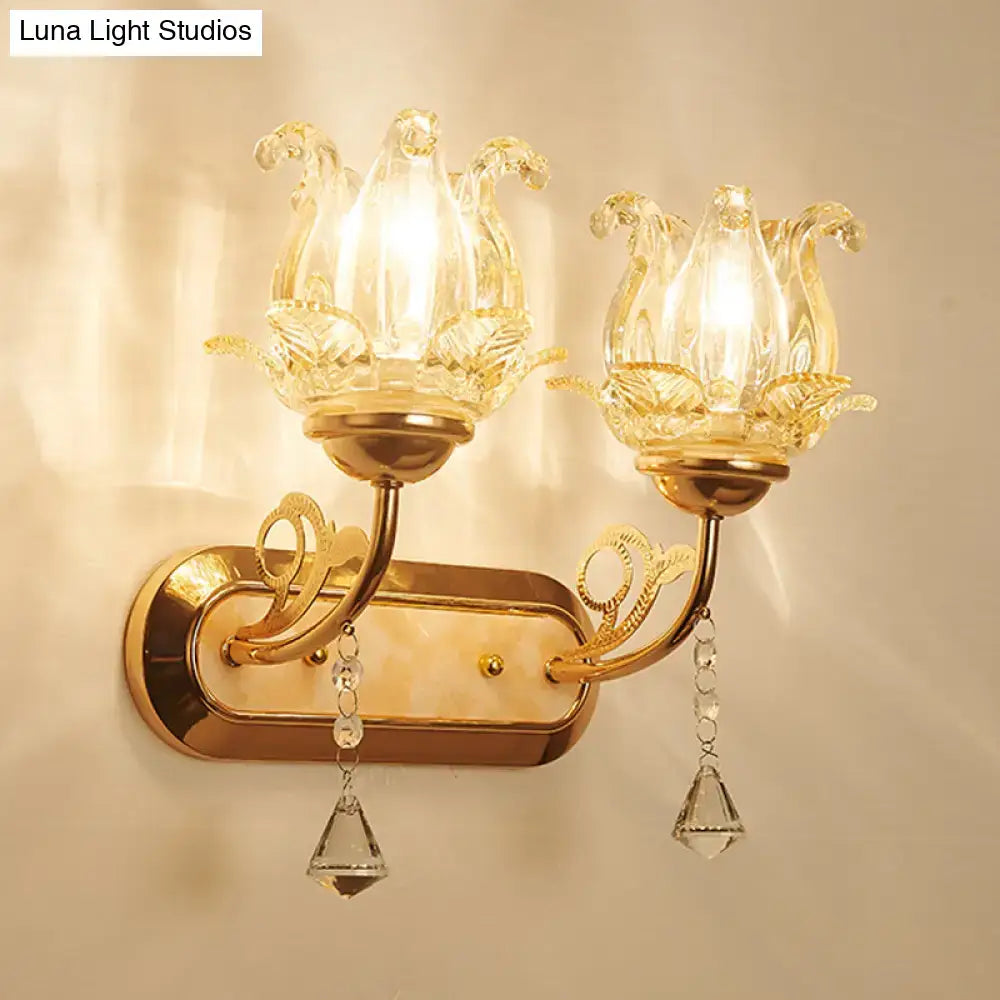 Gold crystal lotus wall lamp with gold finish, two clear glass lotus shades, and dangling crystal pendants for simplicity blossom