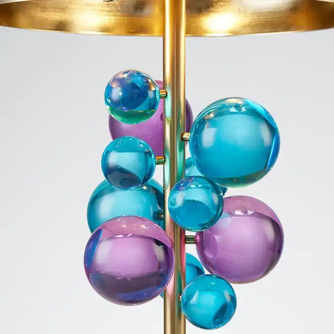 A modern table lamp with a central brass rod and blue purple glass spheres for decorbites crystal marble bubble decor