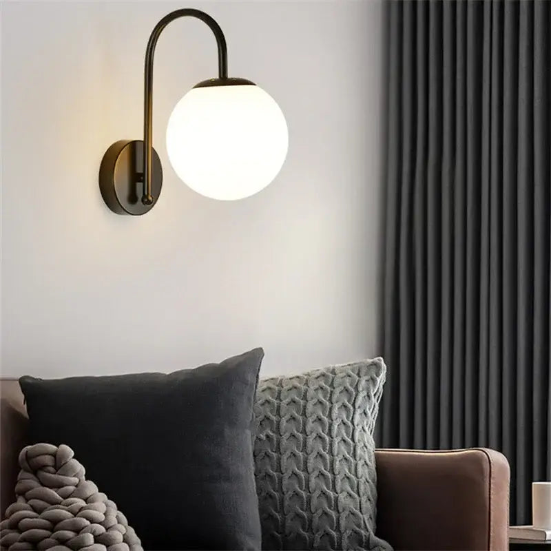 Gold curved arm glass ball led wall sconce with brass finish and frosted decorbites glass ball shade for bedroom light