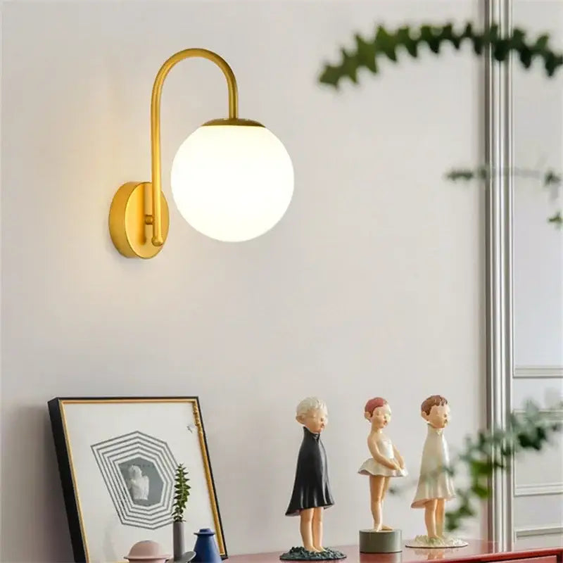 Gold-toned wall sconce with curved arm and frosted glass ball led globe for decorbites glass ball bedroom light