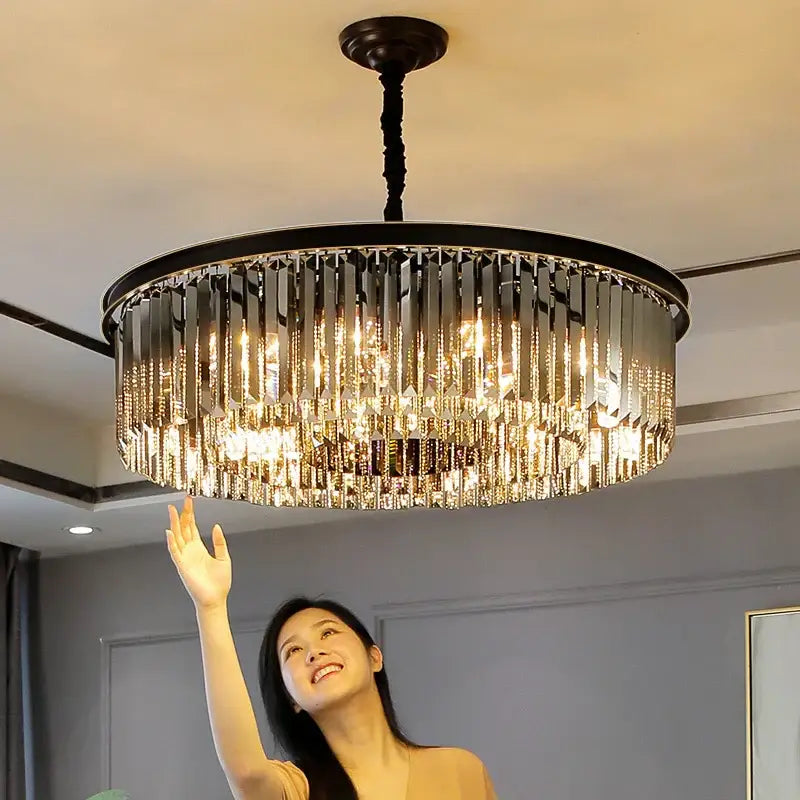 A modern decorbites dual purpose crystal ceiling lamp with a black metal frame and cascading clear faceted prisms