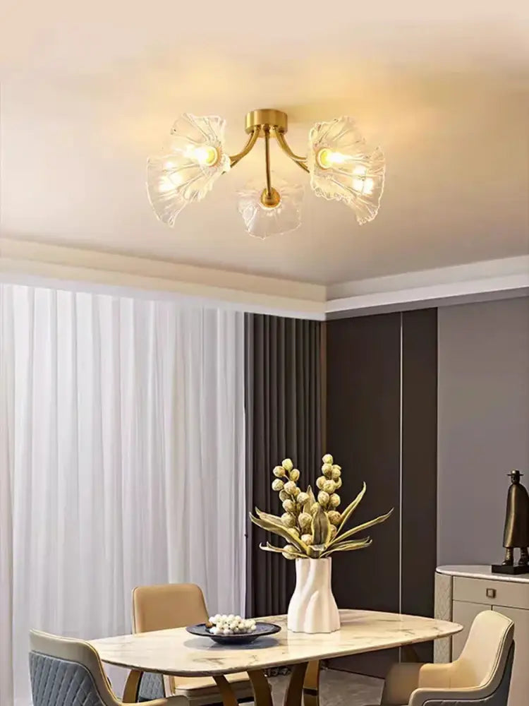 Gold-toned glass flower chandelier ceiling light with three translucent petal-shaped shades for bedroom use