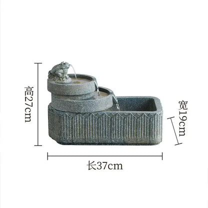 Gray stone fish pond tank fountain with a gold frog figurine flowing water into tiered basins for garden use