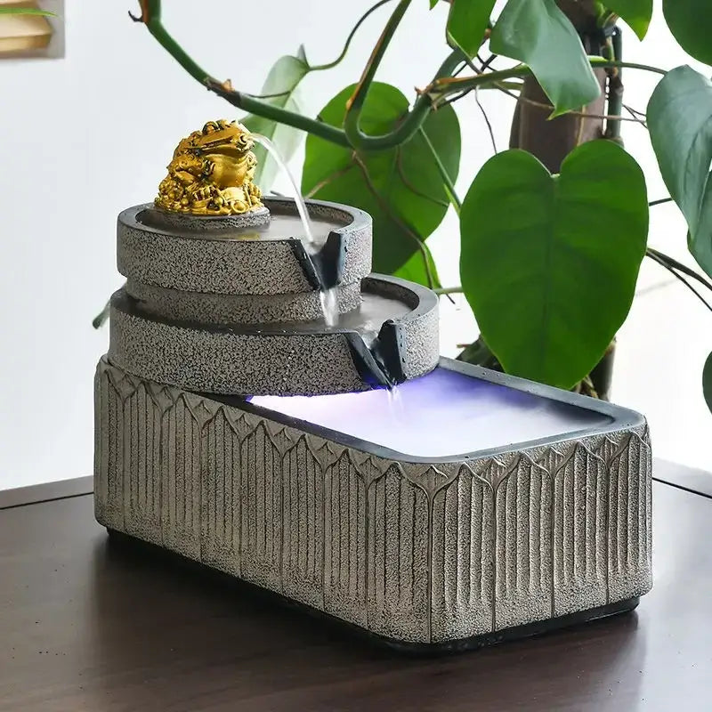 Three-tiered gray stone fish pond tank fountain with golden toad figurine flowing water and illuminated base garden ornament