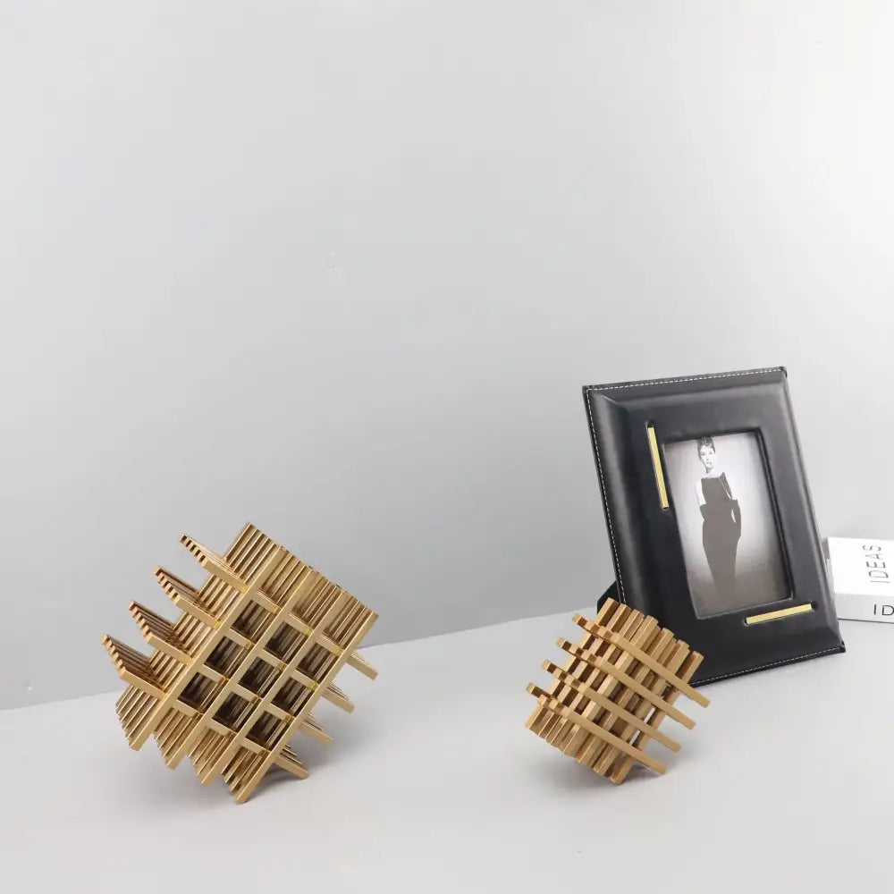 Gold-toned wooden geometric block metal sculpture with intersecting slats forming a lattice pattern decorbites geometric block decor