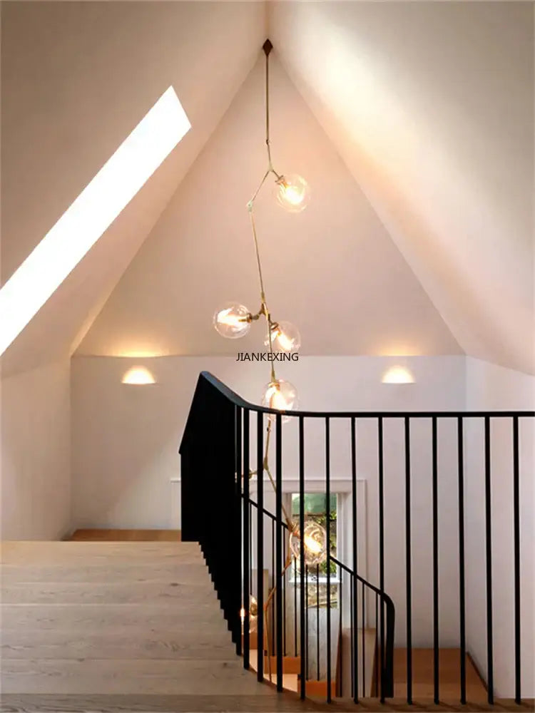 A modern gold glass branching staircase chandelier with clear glass globe bulbs and brass metal arms for dining room decorbites glass branching