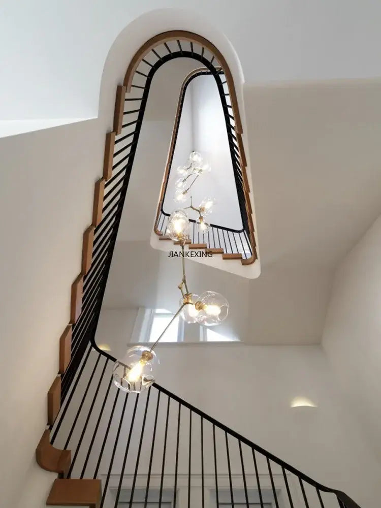 Gold glass branching staircase chandelier with clear glass globe bulbs and gold-toned metal arms for decorbites glass branching decor