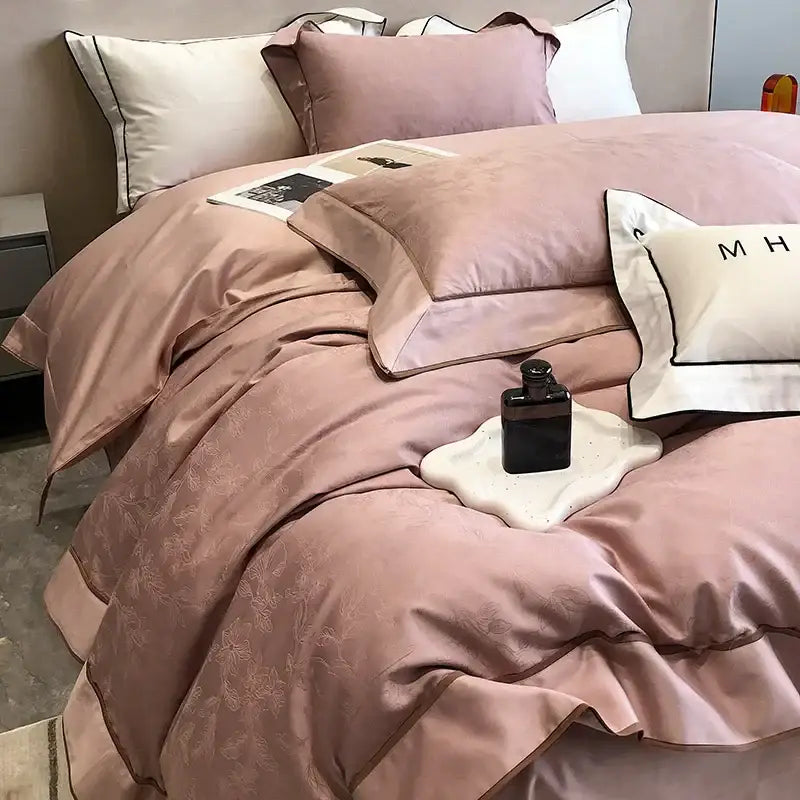 A soft blush pink decorbites jacquard satin bedding set with floral embroidery and dark piping in egyptian cotton patchwork