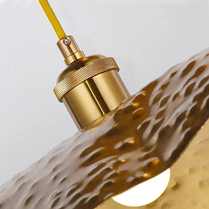 Gold lotus leaf pendant light featuring a gold-toned hammered glass shade brass socket and yellow cord for decorbites gold lotus decor