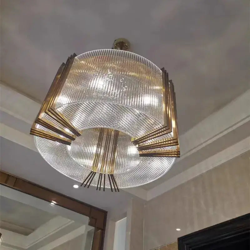 A modern tiered pendant light with clear ribbed glass and gold lustre steel frame by decorbites for dining rooms