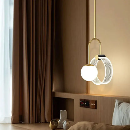 A modern decorbites gold luxury led pendant light with a gold metal frame and white glass spherical bulb for bedroom decor