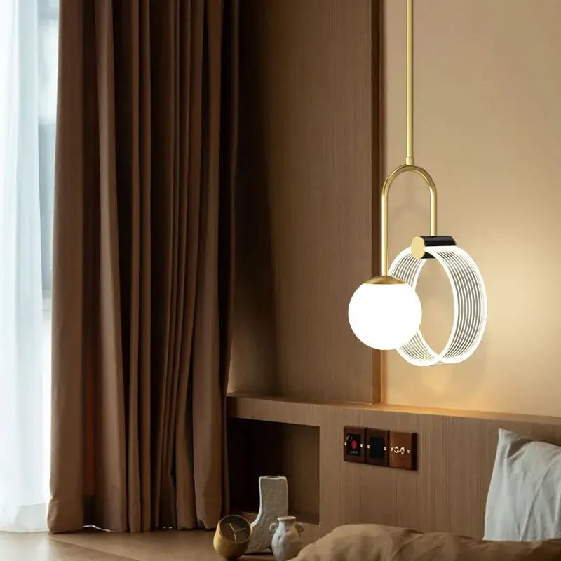 A modern decorbites gold luxury led pendant light with a gold metal frame and white glass spherical bulb for bedroom decor